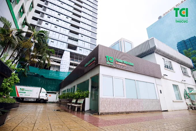 Tòa nhà phòng khám đa khoa Thu Cúc tại Hà Nội với thiết kế hiện đại và xe vận chuyển y tế đỗ phía trước