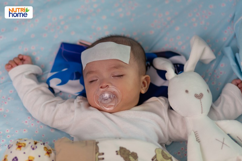 Trẻ sơ sinh nằm sốt nhẹ sau tiêm phòng, được chăm sóc theo dõi tại nhà