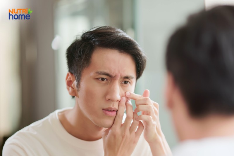 Nam giới soi gương kiểm tra tình trạng da mặt có dấu hiệu lão hóa