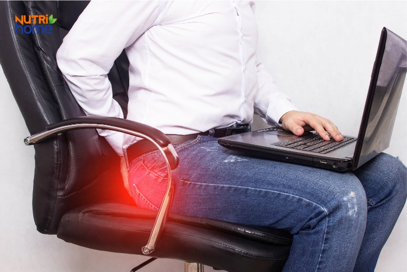 Người đàn ông bị đau vùng hậu môn do bệnh trĩ khi ngồi làm việc lâu