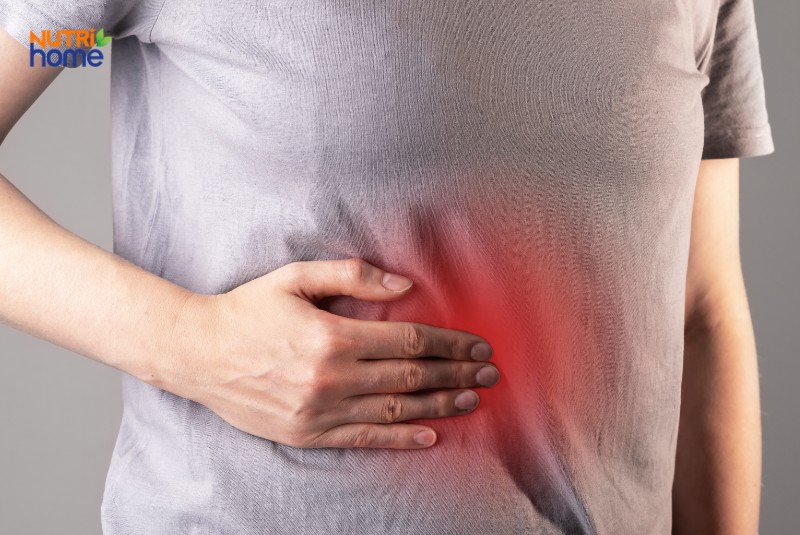 Cơn đau vùng gan được minh họa bằng tay ôm bụng và vùng đỏ, dấu hiệu cảnh báo sớm ung thư