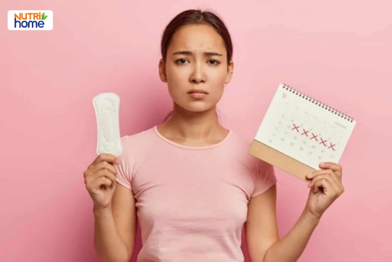 Phụ nữ lo lắng cầm băng vệ sinh và lịch kinh nguyệt có dấu hiệu bất thường