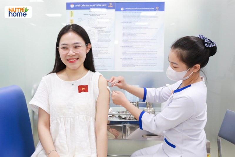 Cô gái trẻ mỉm cười khi tiêm vắc xin HPV tại cơ sở y tế