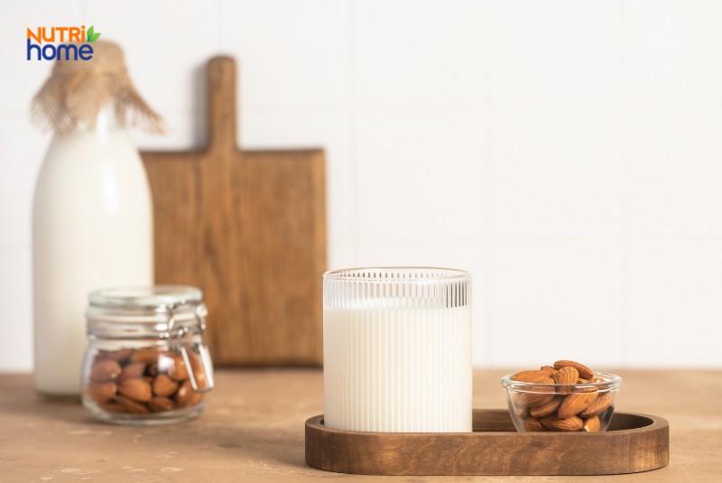 Ly sữa hạnh nhân ít béo đặt cạnh hũ hạnh nhân, phù hợp chế độ ăn cho người viêm tụy