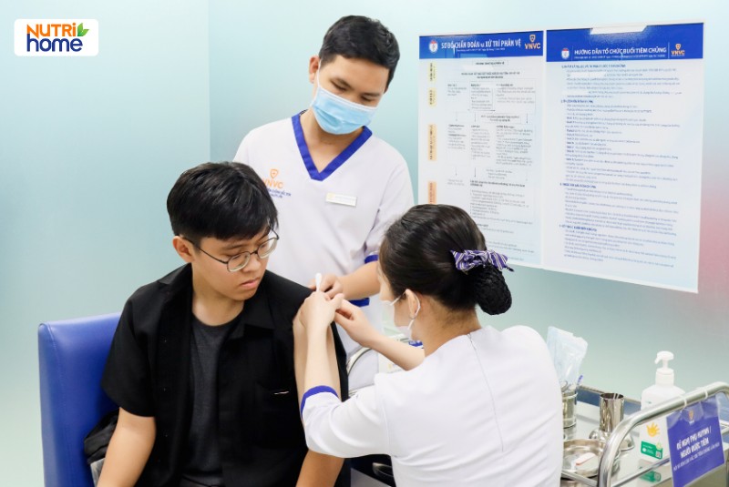 Nam thanh niên được tiêm phòng HPV tại trung tâm tiêm chủng VNVC, có nhân viên y tế theo dõi