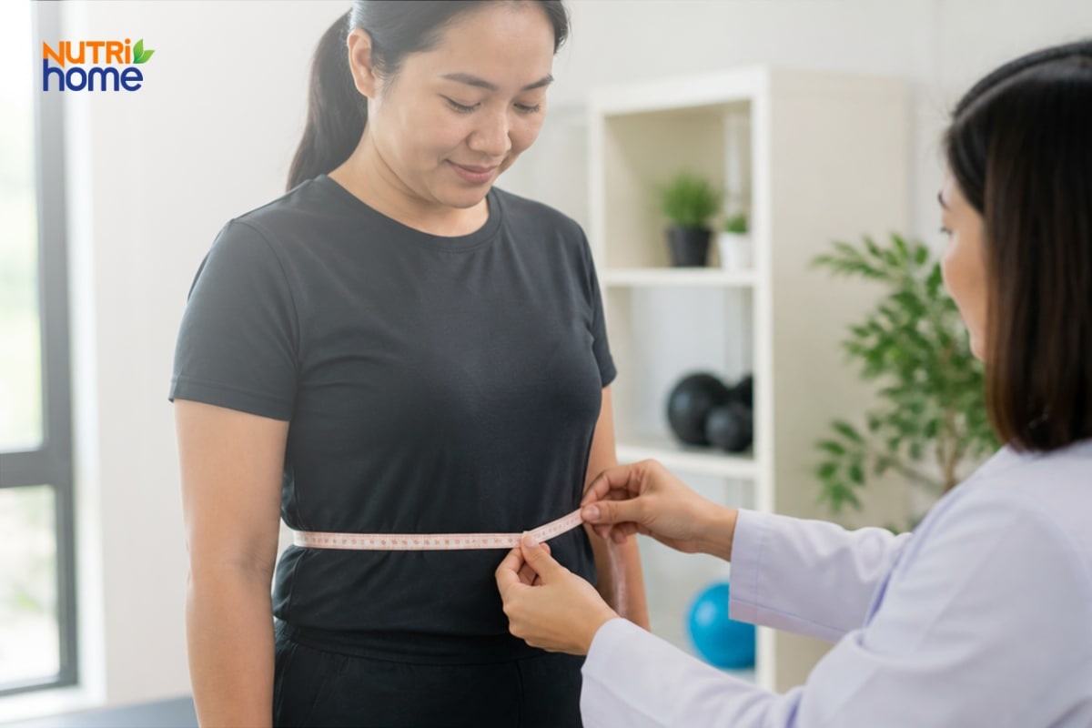 Bác sĩ dùng thước dây đo vòng eo cho một phụ nữ