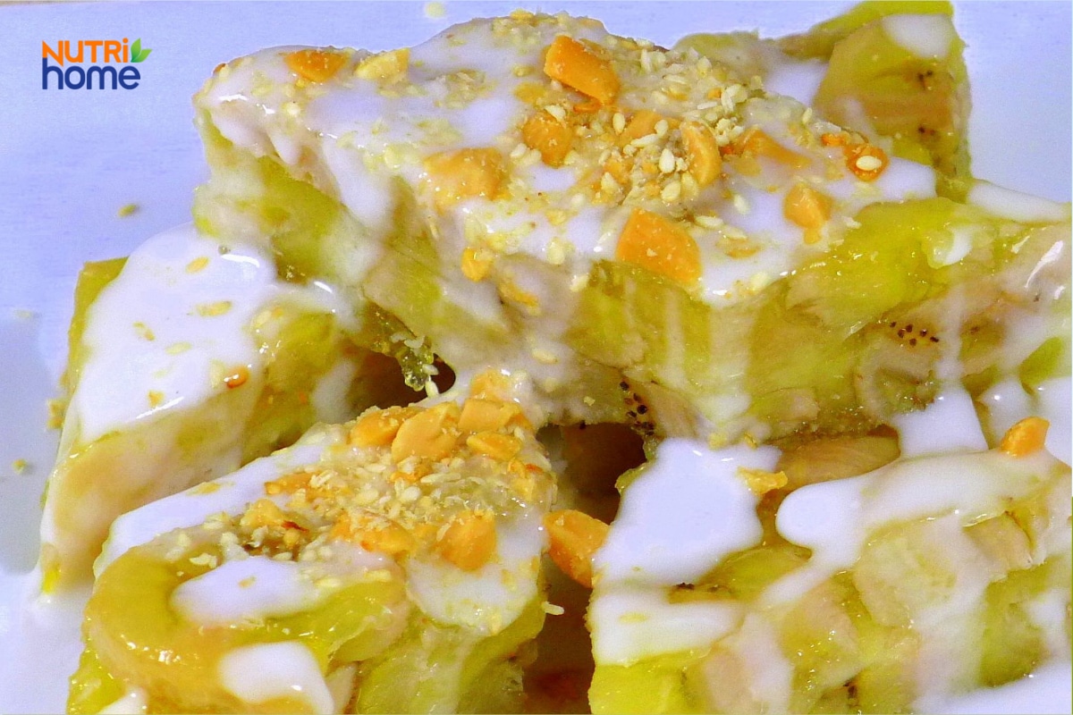 Bánh chuối hấp cắt miếng, phủ nhiều nước cốt dừa và đậu phộng.