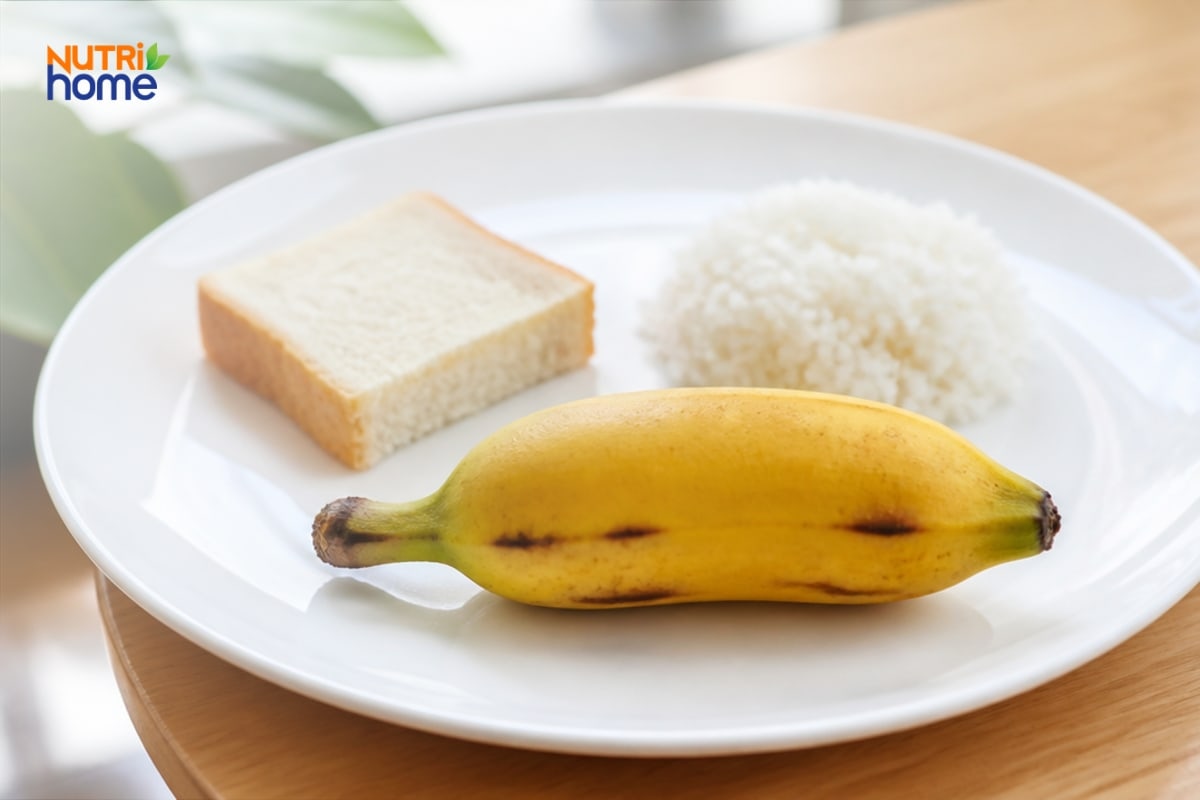 Một quả chuối sứ chín đặt cùng cơm trắng và bánh mì.