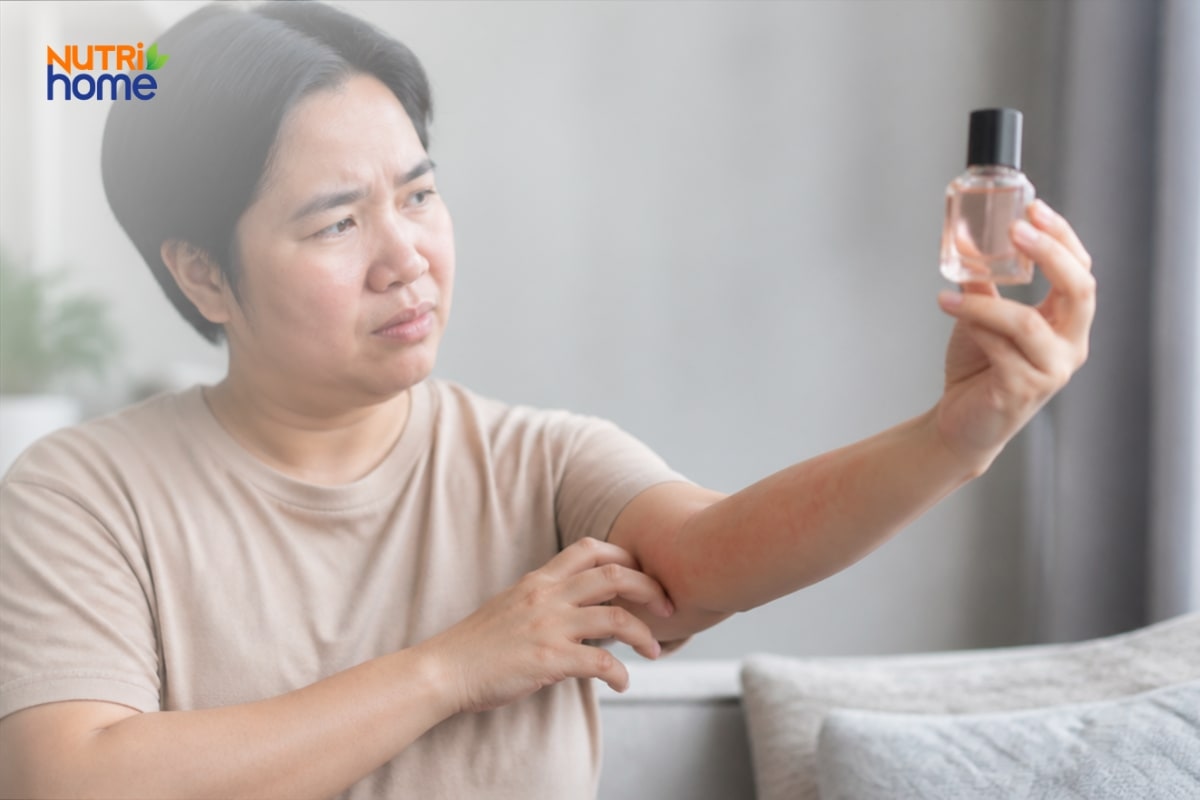 Người phụ nữ quan sát lọ dung dịch khi da tay có dấu hiệu khó chịu.