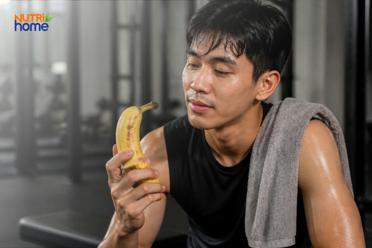 Người đàn ông sau tập luyện đang cầm một quả chuối