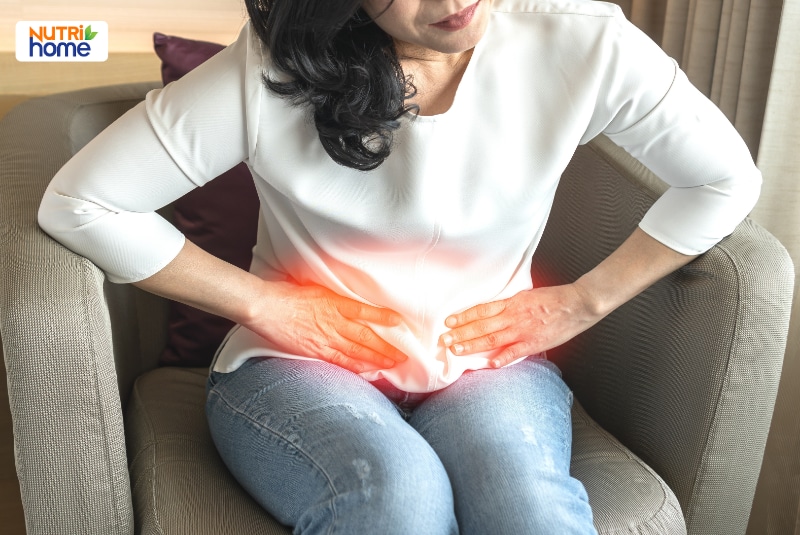 Người phụ nữ ôm vùng bụng dưới do cảm giác đau khó chịu.