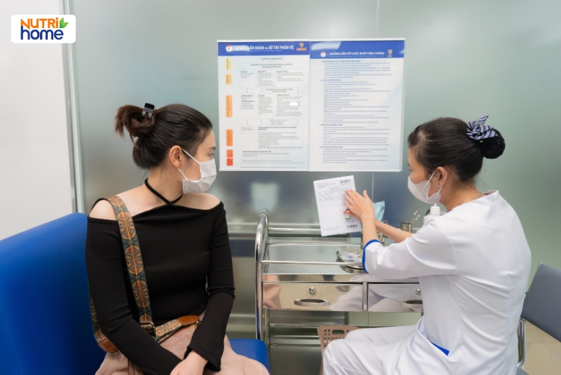 Nhân viên y tế tư vấn thông tin tiêm chủng cho phụ nữ trưởng thành.