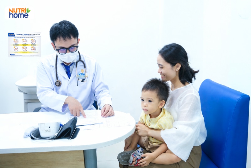 Bác sĩ khám sàng lọc trước tiêm và tư vấn cho mẹ cùng bé trai