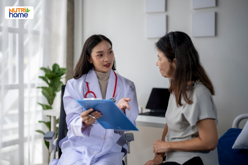 Bác sĩ trao đổi kết quả xét nghiệm với người bệnh nữ tại phòng khám