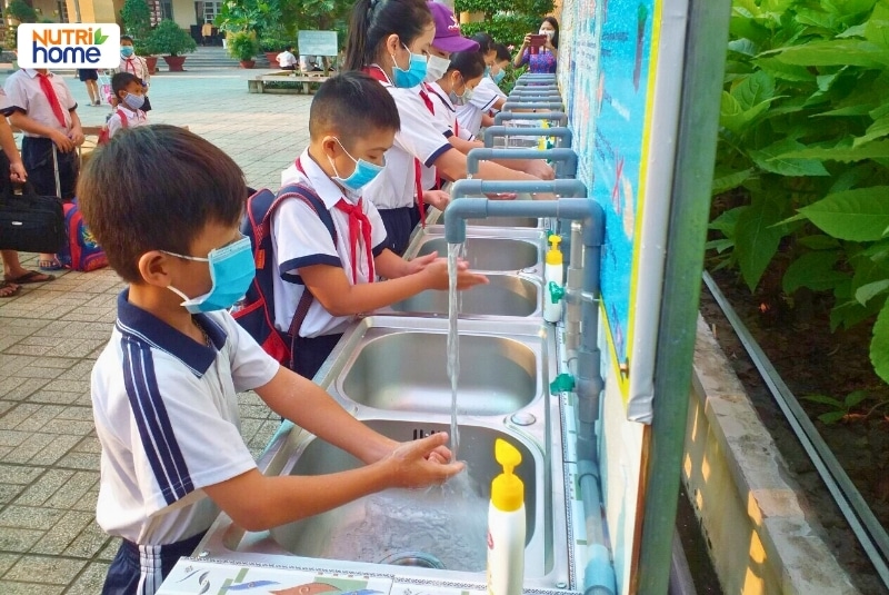 Học sinh xếp hàng rửa tay bằng xà phòng và nước sạch tại bồn rửa ở trường