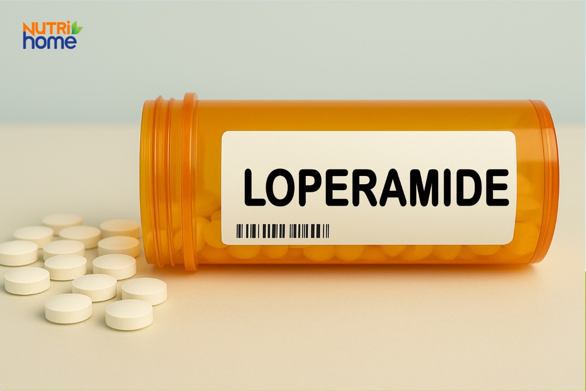Lọ thuốc ghi Loperamide đặt cạnh nhiều viên thuốc màu trắng.