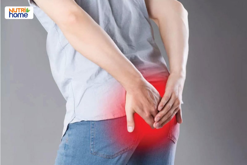 Nam giới đưa tay ôm vùng hậu môn đau, vị trí đau tô màu đỏ