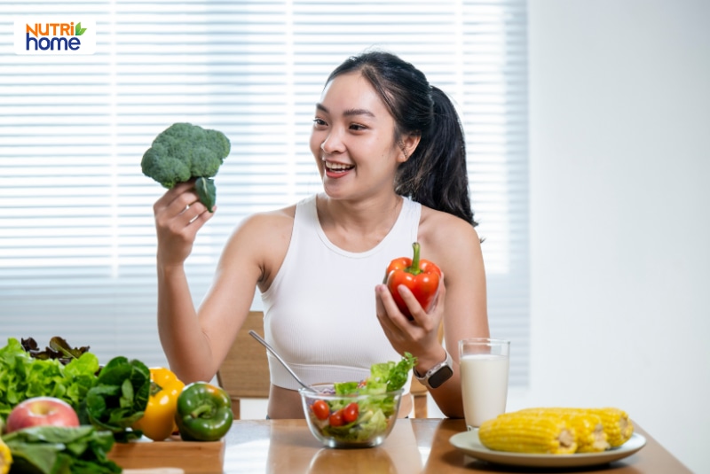 Người phụ nữ vui vẻ ăn rau củ và salad giúp tăng cường miễn dịch